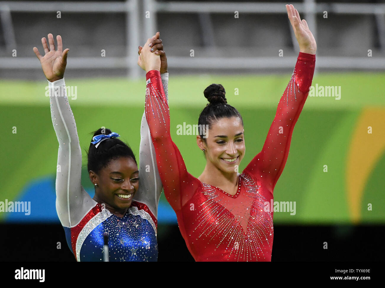 Aly Raisman and Simone Biles of the United States raise their hands ...