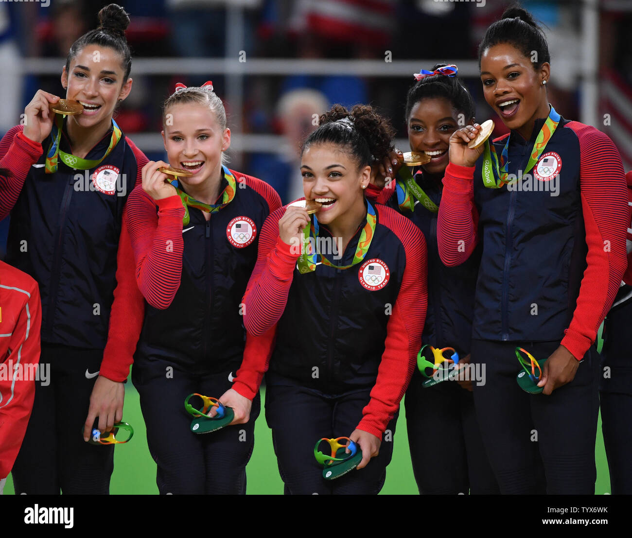 American gymnasts Aly Raisman, Madison Kocian, Lauren Hernandez, Simone Biles and Gabby Douglas (L-R) hold up their medals on the winners podium after taking home gold in the Women's Artistic Gymnastics finals of the 2016 Rio Summer Olympics in Rio de Janeiro, Brazil, August 9, 2016. Photo by Kevin Dietsch/UPI Stock Photo