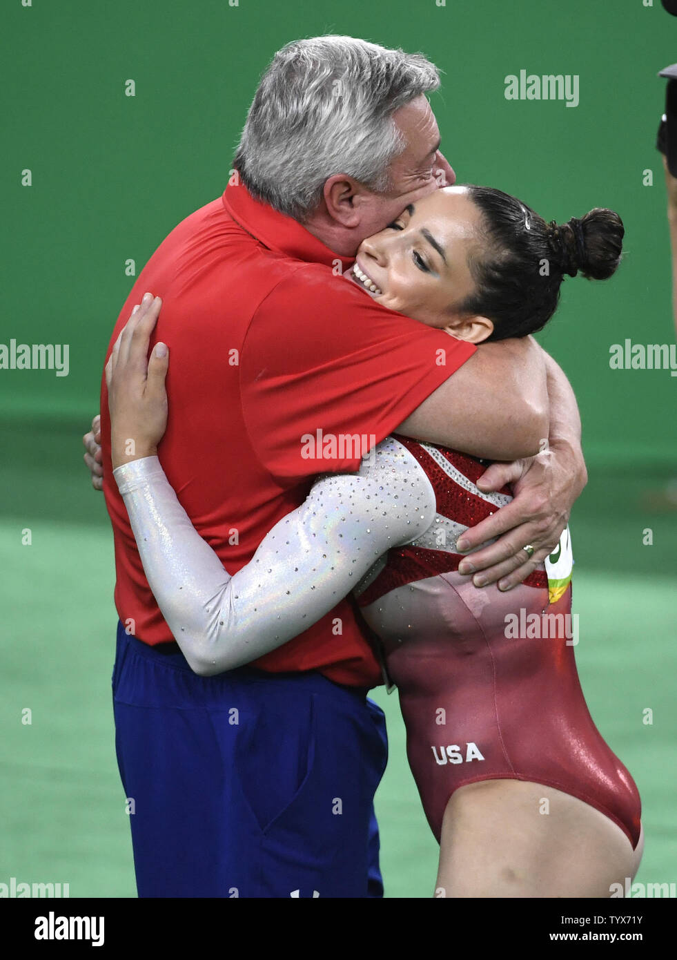 American gymnast Aly Raisman (R) is hugged by coach Mihai Brestyan ...