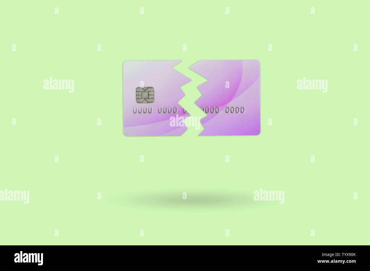 Cut and broken pink credit card floating in the pastel green space. The concept of ban to use banking services. Credit card expire end soon Stock Photo