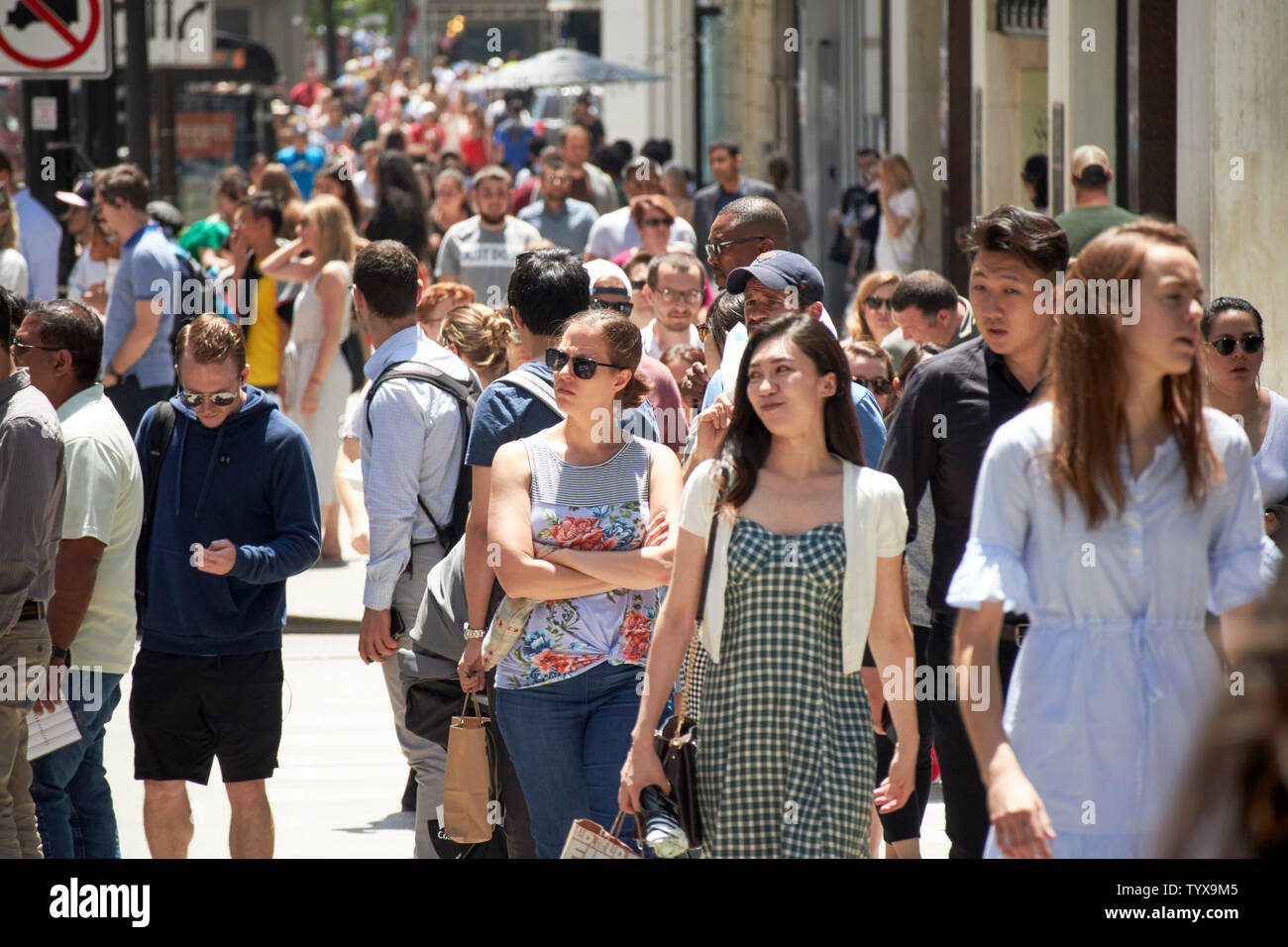 People walking along michigan avenue on a hot summers day in downtown Chicago IL USA Stock Photo