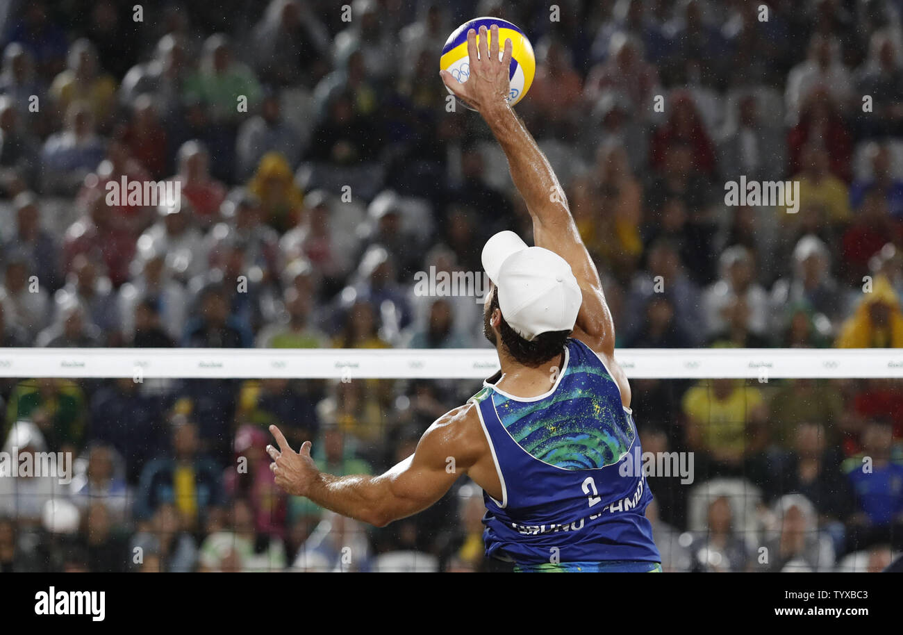 Alison Cerutti of Brazil celebrates hits the ball over the net in the