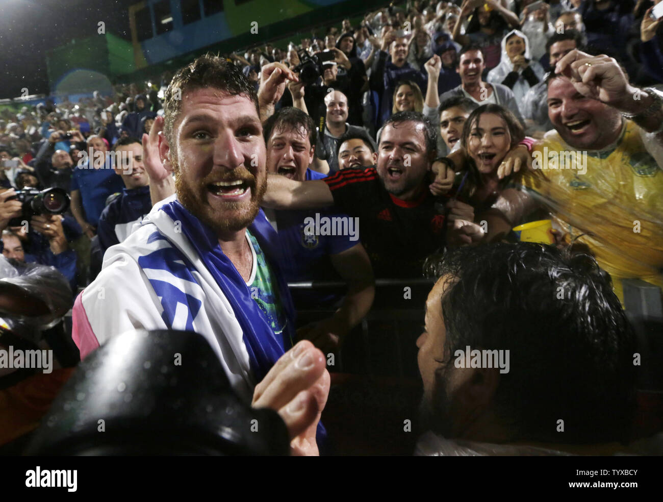 Alison Cerutti of Brazil celebrates with fans after winning the Men's