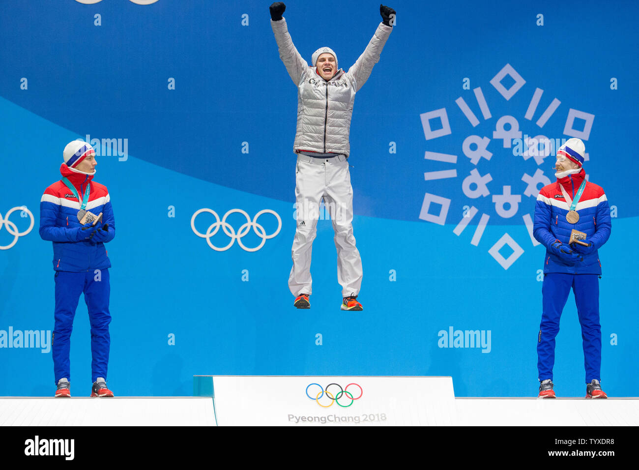 Men's normal hill ski jumping gold medalist Andreas Welling of Germany jumps on the podium during a medal ceremony for the Pyeongchang 2018 Winter Olympics, at the Olympic Medal Plaza in Daegwalnyeong, South Korea, on February 11, 2018. Looking on are silver medalist Andre Forfang (L) and bronze medalist Robert Johansson both of Norway. Photo by Matthew Healey/UPI Stock Photo