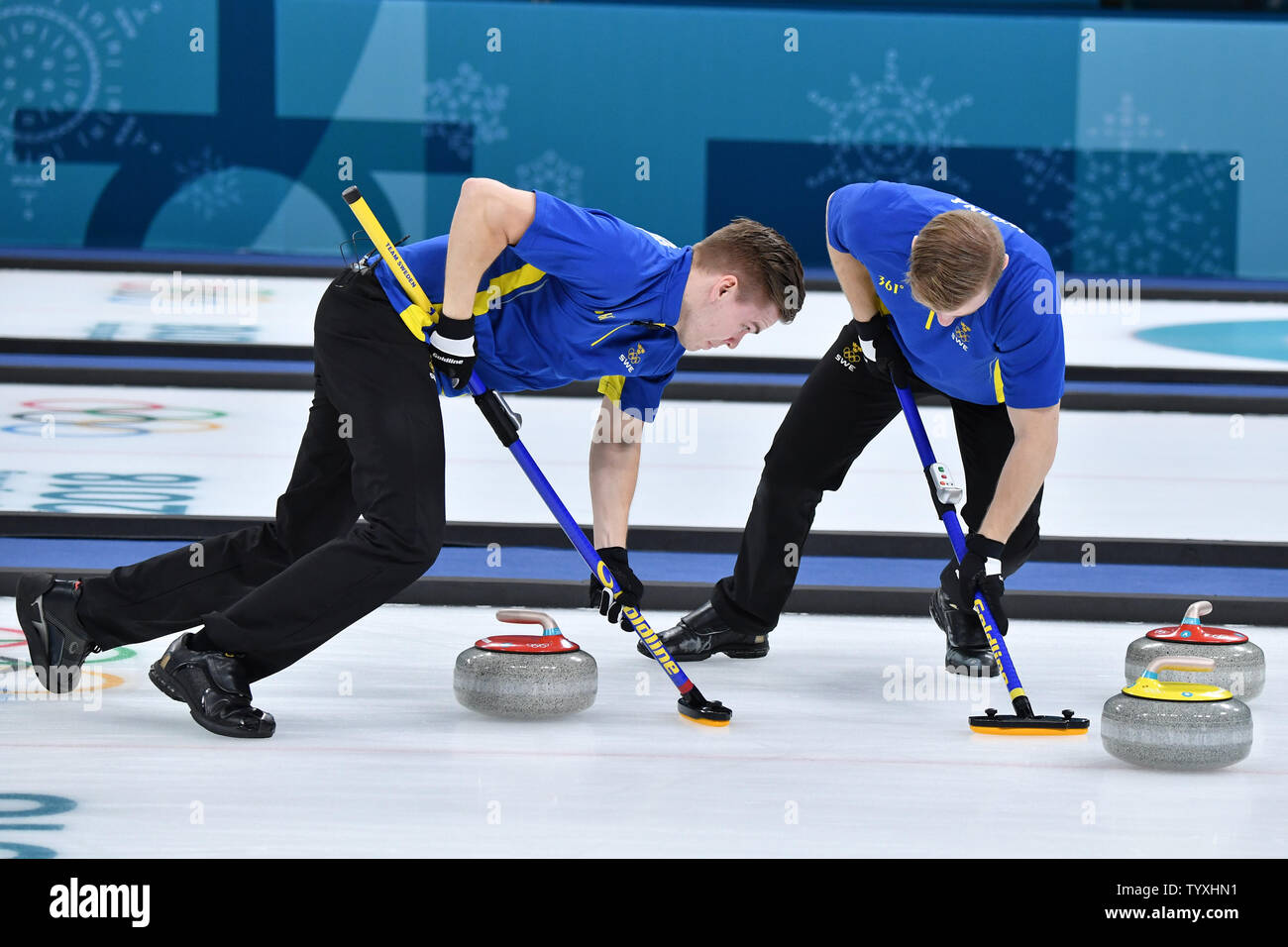 Members of Team Sweden sweep ahead of the stone during the Men's Curling  finals at the Pyeongchang 2018 Winter Olympics, in the Gangneung Curling  Centre in Gangneung, South Korea, on February 24,