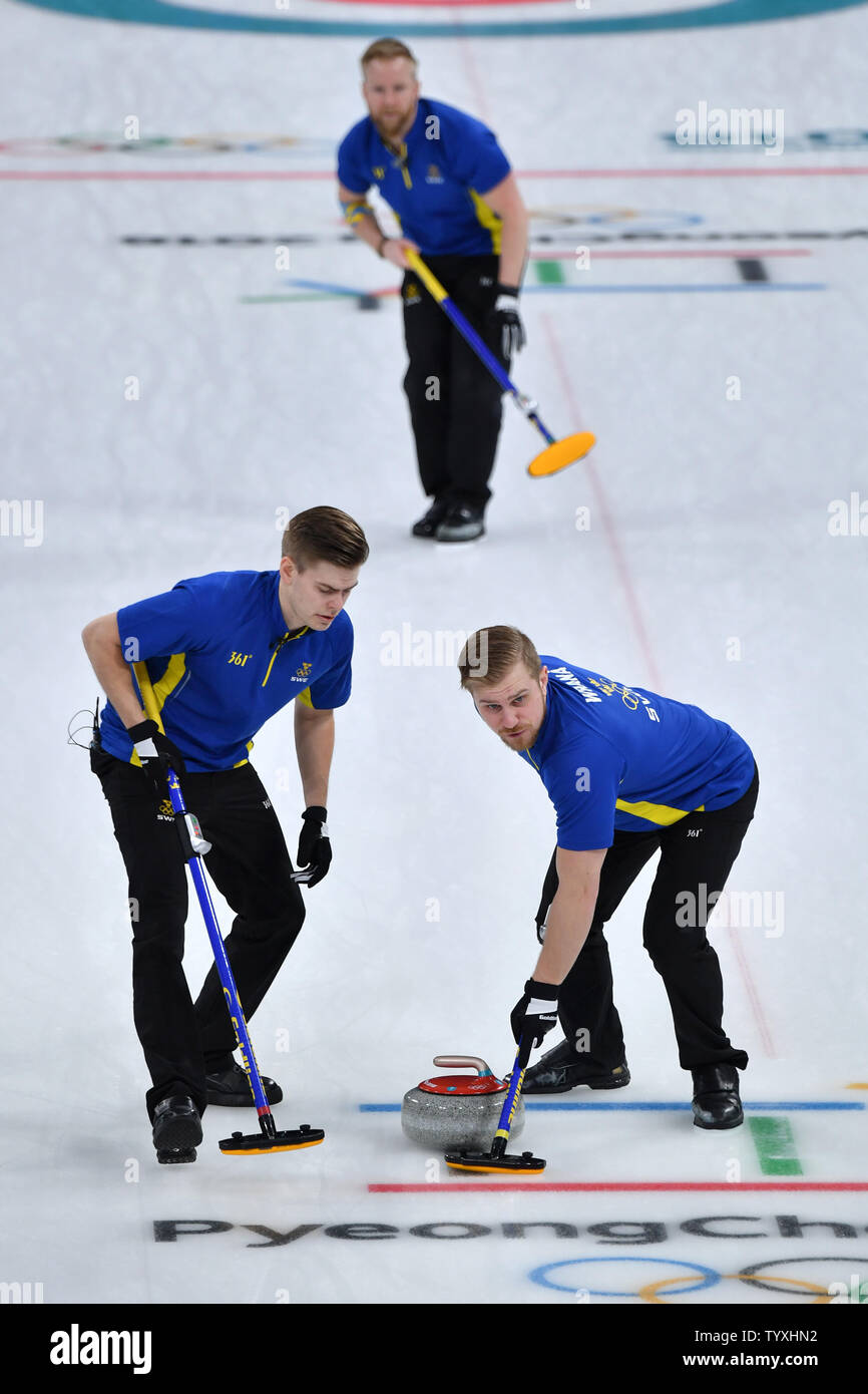 Members of Team Sweden sweep ahead of the stone during the Men's Curling  finals at the Pyeongchang 2018 Winter Olympics, in the Gangneung Curling  Centre in Gangneung, South Korea, on February 24,
