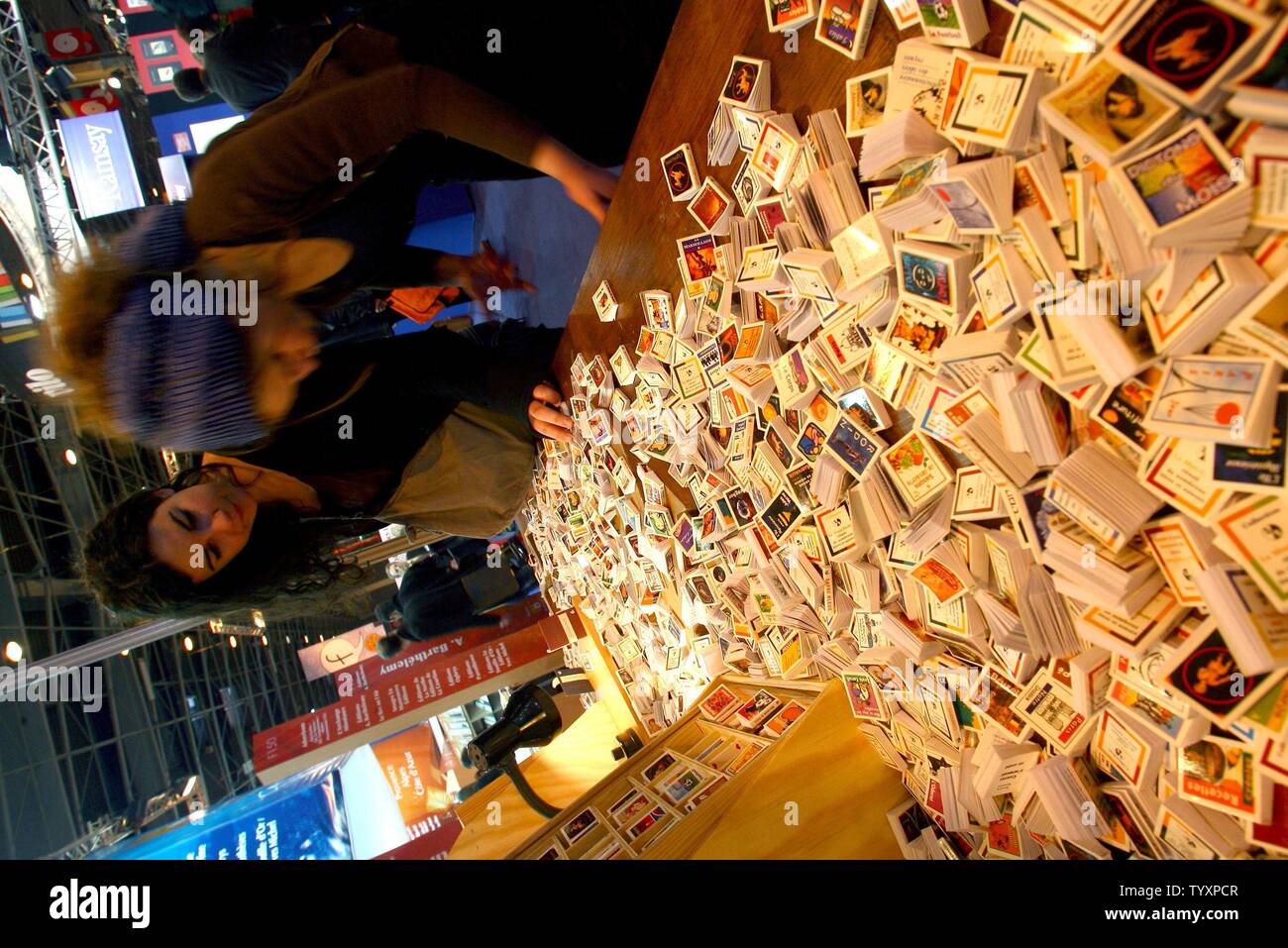 Young women browse through miniature books on display at a stand on the opening day of the 26th Paris Book Fair, March 17, 2006. Some 2,000 writers were invited to the fair which is to run until March 22..  (UPI Photo/Maya Vidon) Stock Photo