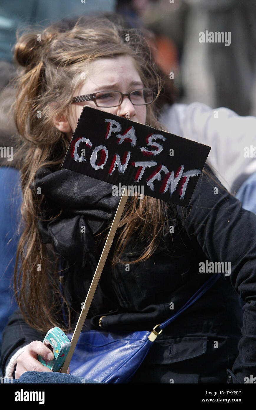 A French student holds a sign that reads 'Not Happy'  during a protest march along one of Paris' main avenues April 11, 2006. Hundreds of students, emboldened by President Jacques Chirac's cave-in on the First Employment Contract (CPE), went ahead with a pre-planned demonstration in a bid to get rid of other government labor reforms.  (UPI Photo/Eco Clement) Stock Photo