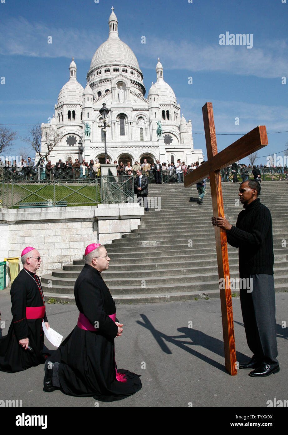 Archbishop of Paris Monseigneur Andr Vingt-Trois (R) genuflects at the steps of the Sacre Coeur Basilica during the 'Stations of the Cross' Good Friday ritual in the Montmartre area of Paris on April 6, 2007.  The ritual symbolically represents the final hours of the life of Jesus Christ.   (UPI Photo/ David Silpa) Stock Photo