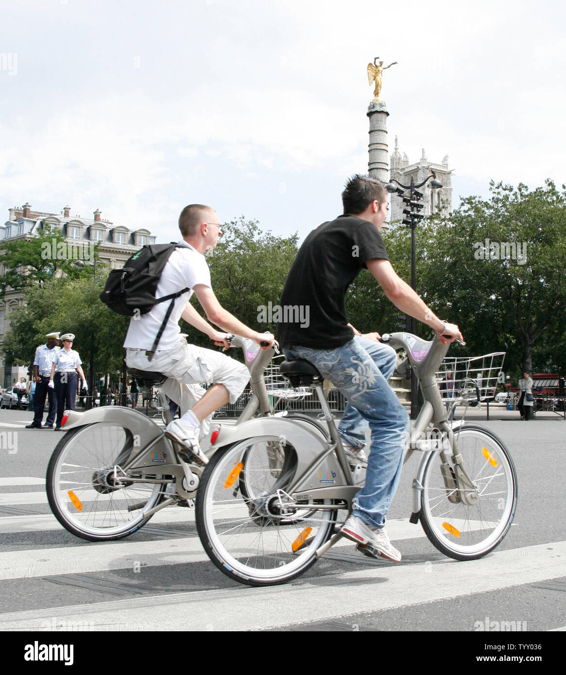 Two riders pass the Place du Chatelet after being among the first to rent a bicycle following the official launch of the 'Velib' citywide bicycle program in Paris on July 15, 2007.  Parisians and visitors can rent a bicycle free of charge for the first half hour from among the new fleet of 20,000 that will be available from approximately 750 automatic kiosks around the city.   (UPI Photo/ David Silpa) Stock Photo