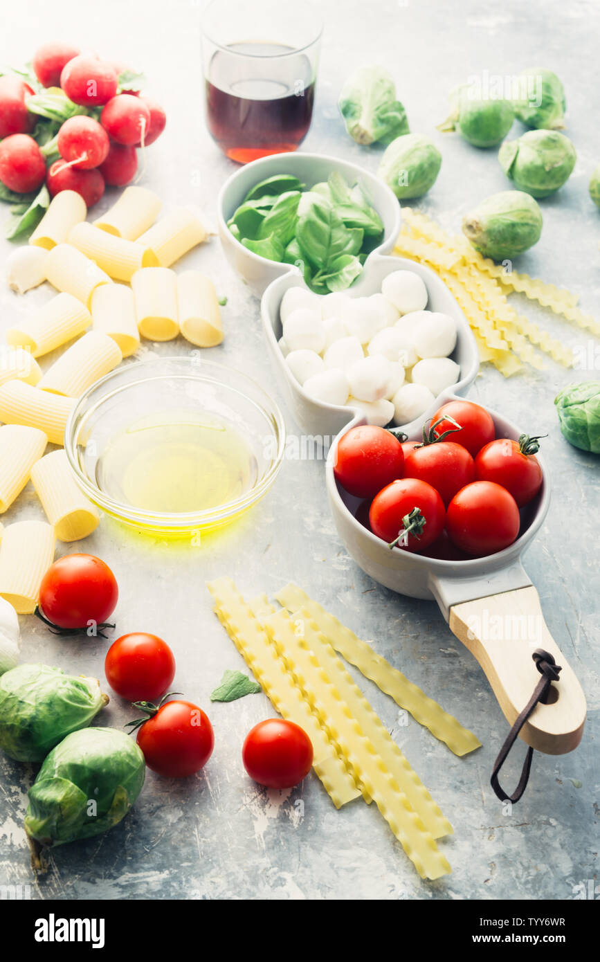 Tomato basil and mozzarella. Food Ingredients pattern with mozarella cheese balls and fresh basil leaves, round cherry tomatoes, with pasta, and wine, Stock Photo