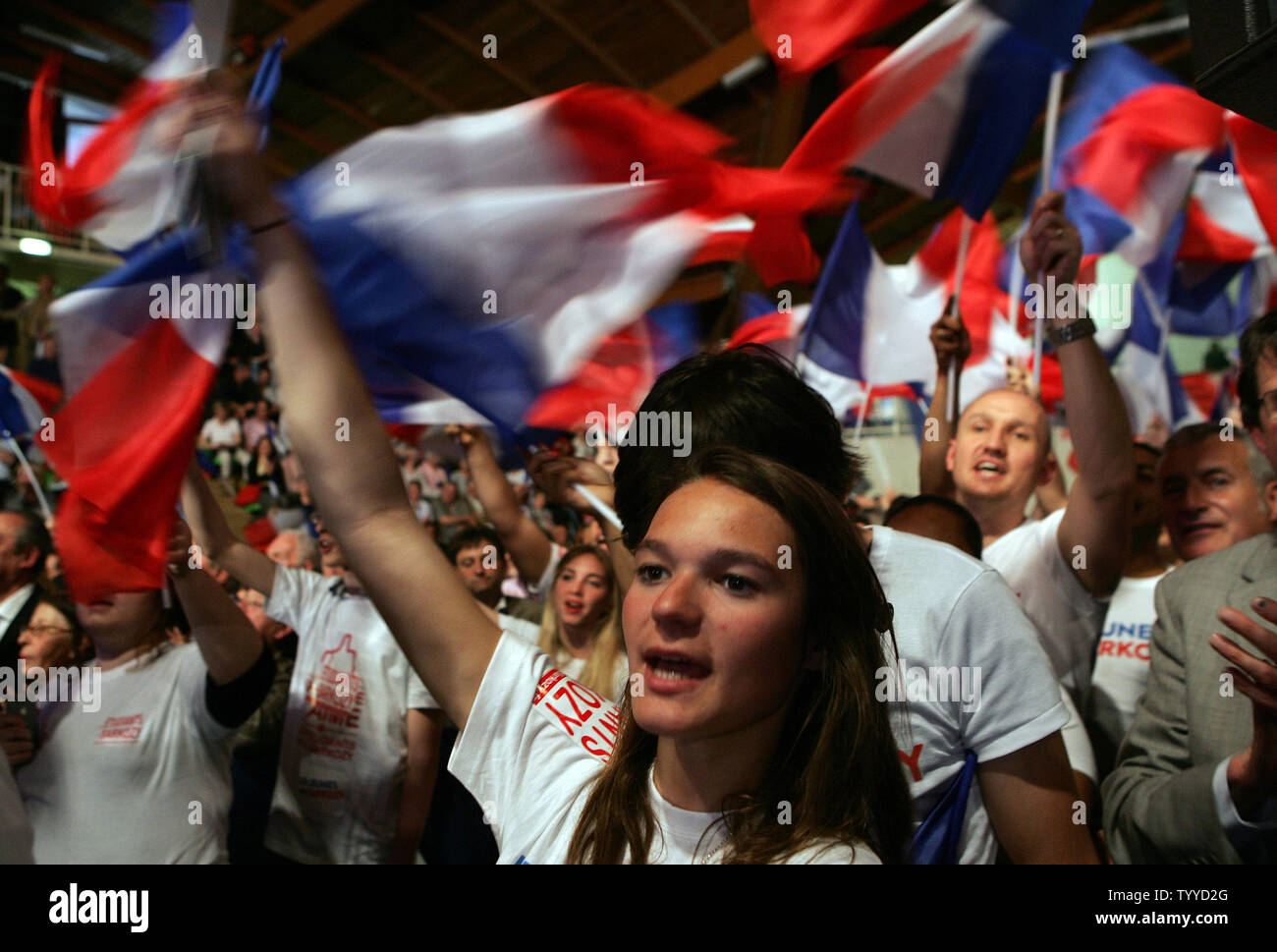 Youths wave the national flag as French President Nicolas Sarkozy campaigns at a public meeting on March 28, 2012 in Elancourt, near Paris, France. Polls showed that the conservative candidate has caught up with his Socialist challenger in the first round of a presidential election next month. UPI/Eco Clement Stock Photo