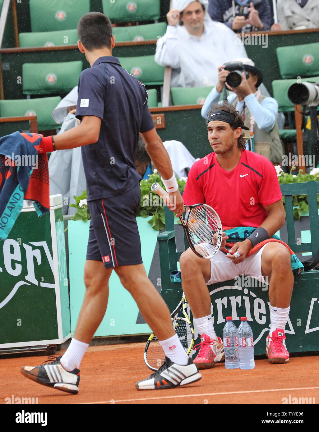 Serbian Novak Djokovic (L) discusses the falling rain with Spaniard Rafael  Nadal during their French Open men's final match at Roland Garros in Paris  on June 11, 2012. Nadal defeated Djokovic 6-4,