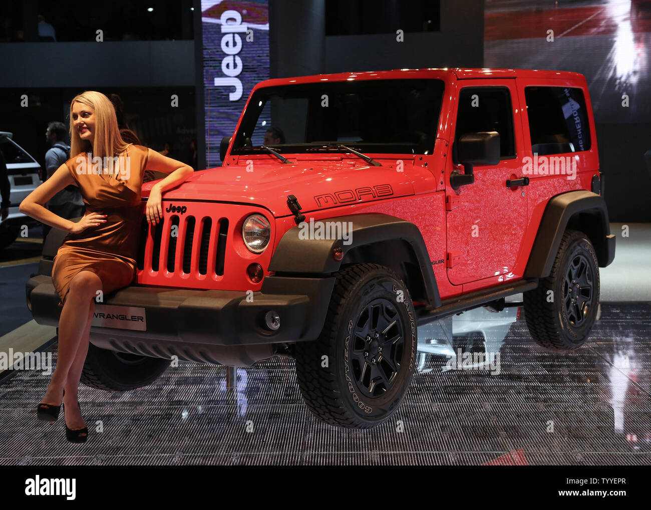 A model sits on a 2013 Jeep Wrangler Moab Edition on display during press  day at the biennial Paris Motor Show in Paris on September 27, 2012. The  show, the first motor