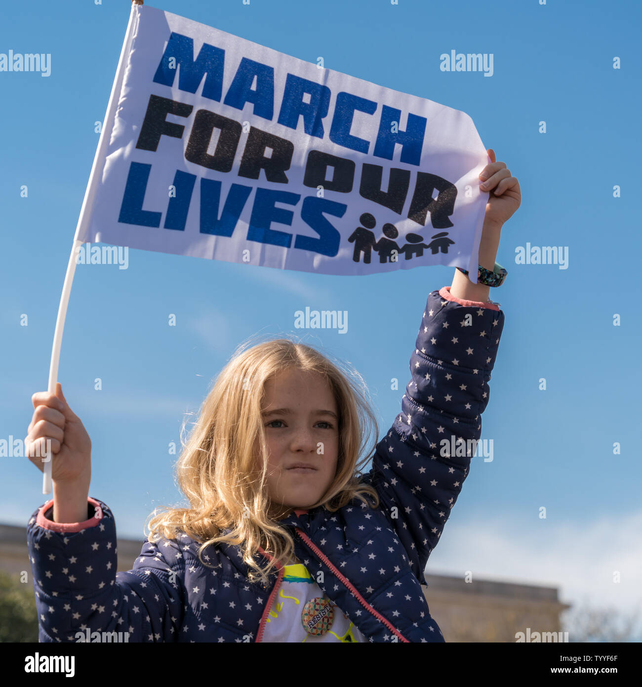 A young girl holds up a 'March for our Lives' flag at the March for our Lives rally in Washington, DC, USA on March 24, 2018. Stock Photo