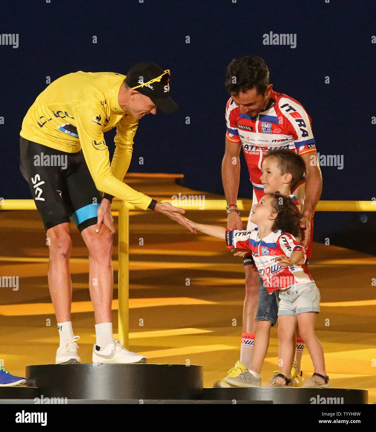 Chris Froome Of Great Britain L Gets Congratulated By The Children Of Third Place Finisher Joaquim Rodriguez Oliver Of Spain On The Presentation Podium After Froome Won The Tour De France In
