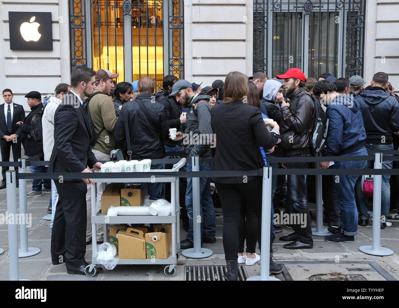 Apple employees serve coffee to customers as the line up in front of the Apple Store near Place de l'Opera before the launch of the new iPhone5s and iPhone5c today in Paris on September 20, 2013.  The iPhone 5s features a new Touch ID fingerprint sensor on the home button that allows users to unlock their phone without using a password while the iPhone 5c offers users a choice of various colors.   UPI/David Silpa Stock Photo