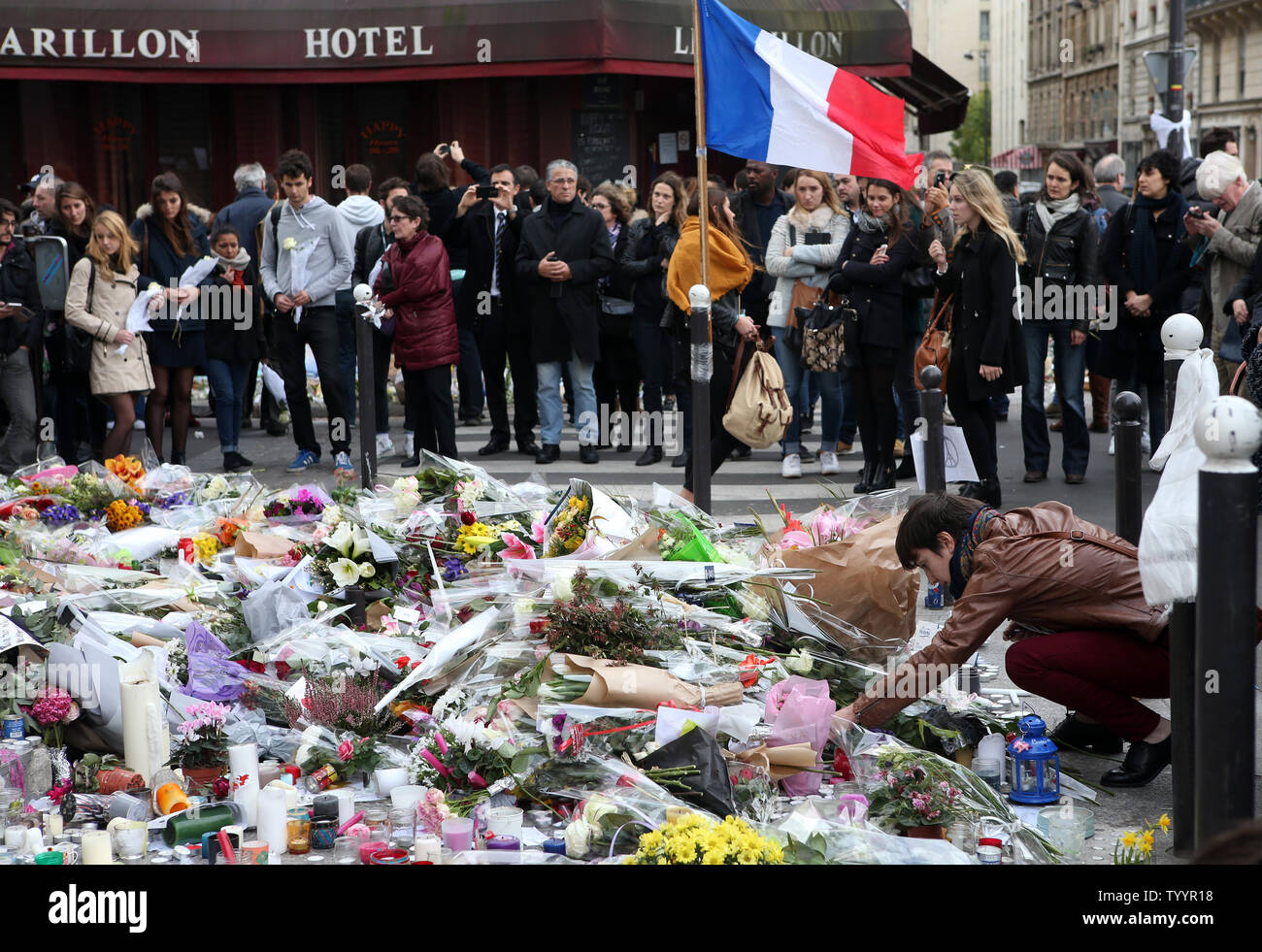 People mourn in front of Le Carillon bistro and Le Petit Cambodge restaurant facing each other after they were  targeted in the Paris attacks Nov 16, 2015. More than one hundred people were killed and many more wounded when gunmen opened fire inside the venue as the French capital has been the target of a series of deadly attacks.  Photo by Maya Vidon-White/UPI Stock Photo