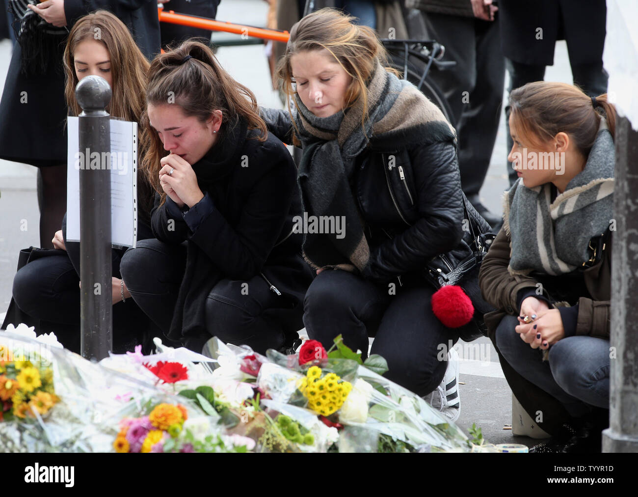 People mourn in front of Le Carillon bistro and Le Petit Cambodge restaurant facing each other after they were  targeted in the Paris attacks Nov 16, 2015. More than one hundred people were killed and many more wounded when gunmen opened fire inside the venue as the French capital has been the target of a series of deadly attacks.  Photo by Maya Vidon-White/UPI Stock Photo
