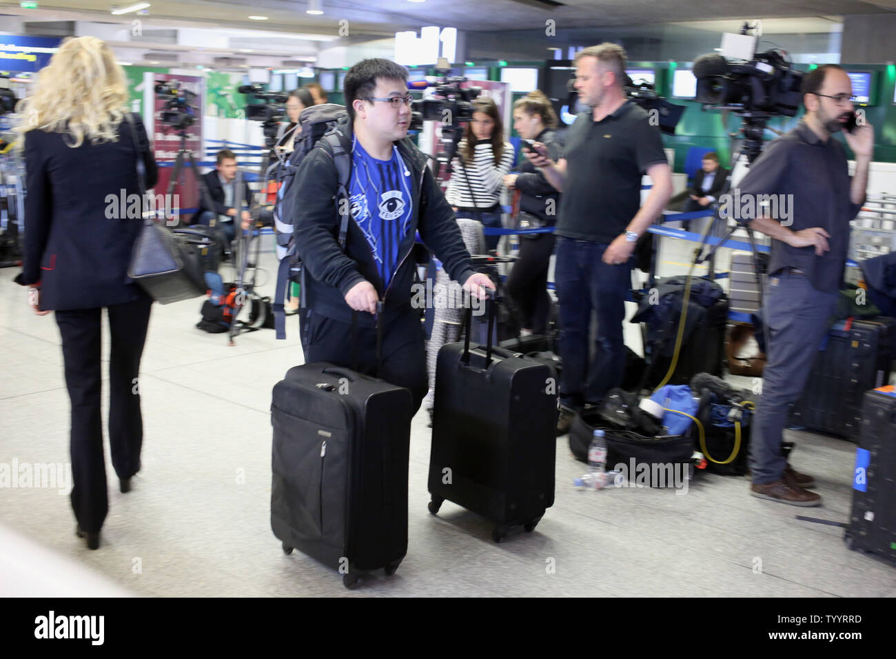 A traveller drags his luggages past a wall of journalists set up in front of the EgyptAir counter at the departure hall of Roissy-Charles de Gaulle's airport, on the outskirts of Paris, on 19 May 2016.  EgyptAir flight MS804 crashed early morning on its way from Paris to Cairo allegedly killing all 66 people on board.  Photo by Eco Clement/UPI Stock Photo
