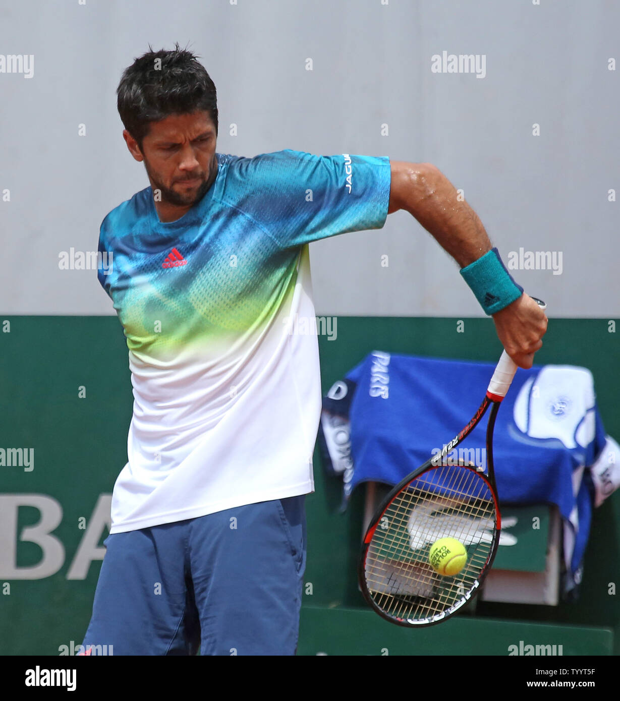 Fernando Verdasco of Spain hits a behind the back shot during his French  Open men's third round match against Kei Nishikori of Japan at Roland Garros  in Paris on May 27, 2016.