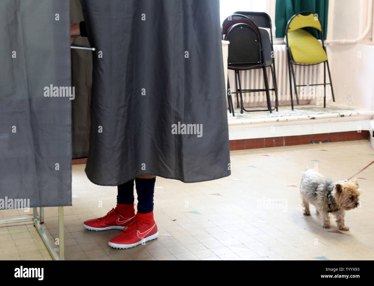 A French Voter Casts His Ballot Behind The Curtains Of A Voting