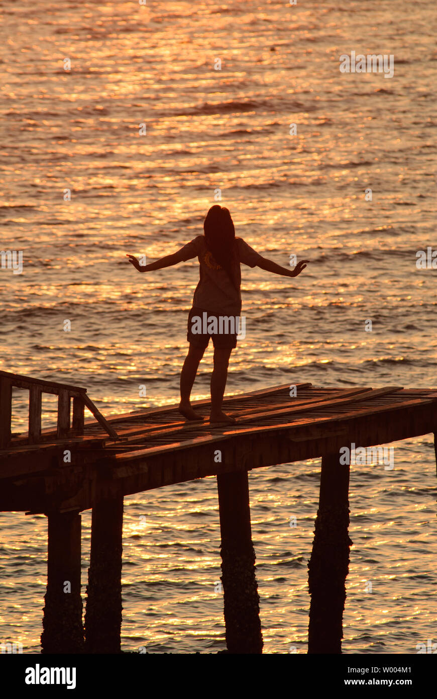 Woman watching sunset beach arms hi-res stock photography and images ...