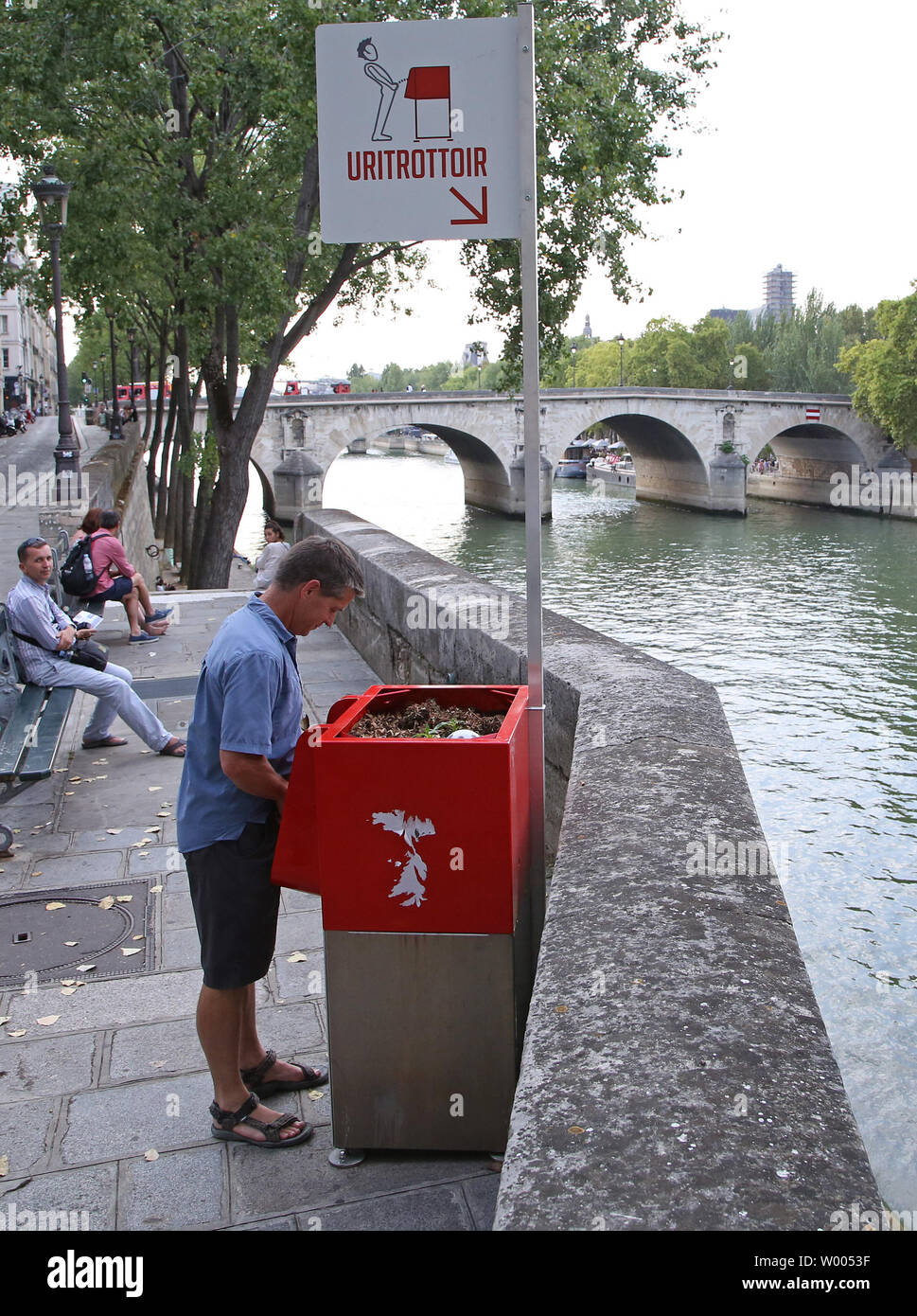 A man stands in front of a new, openair urinal on Ile SaintLouis in