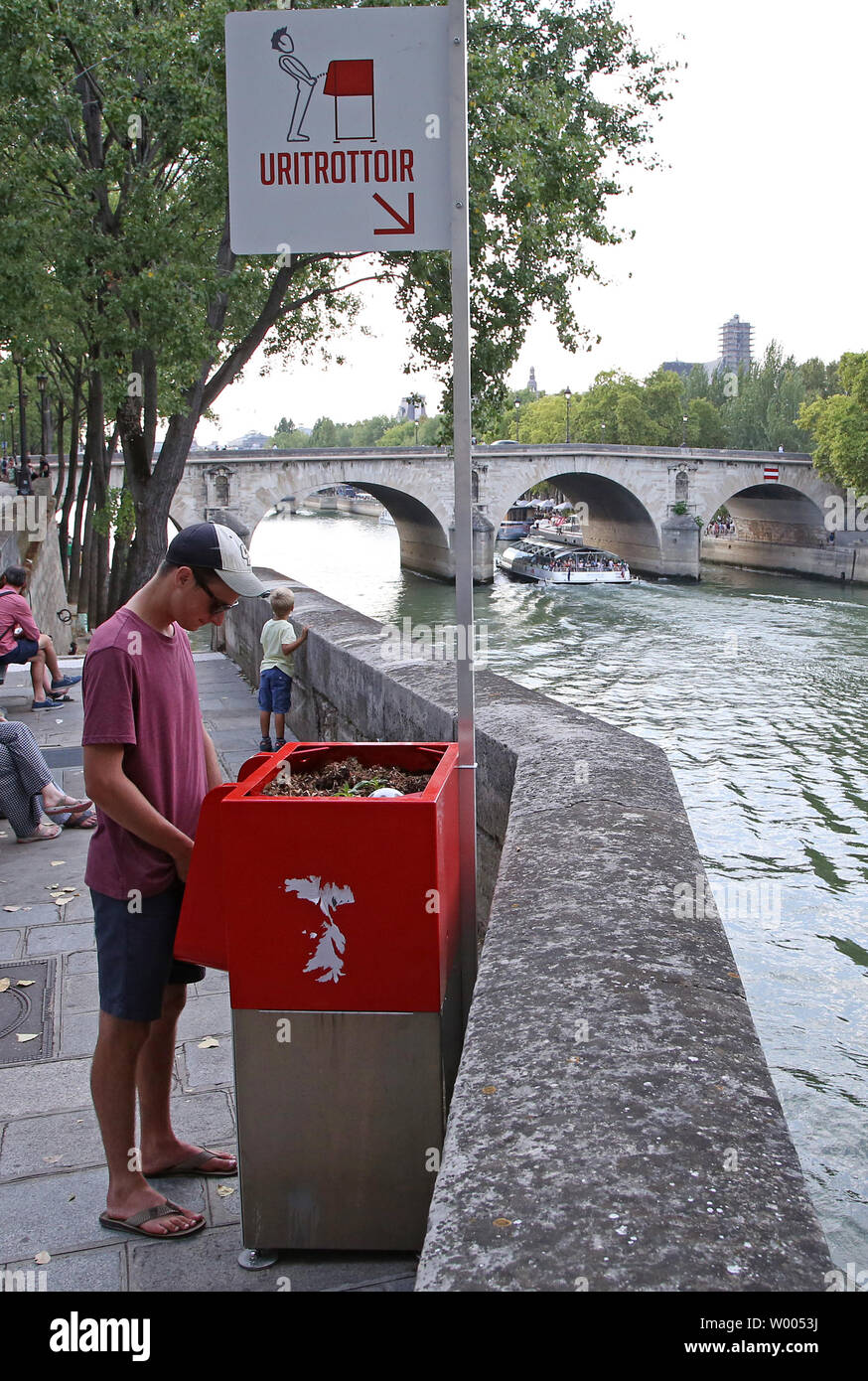 A man stands in front of a new, openair urinal on Ile SaintLouis in
