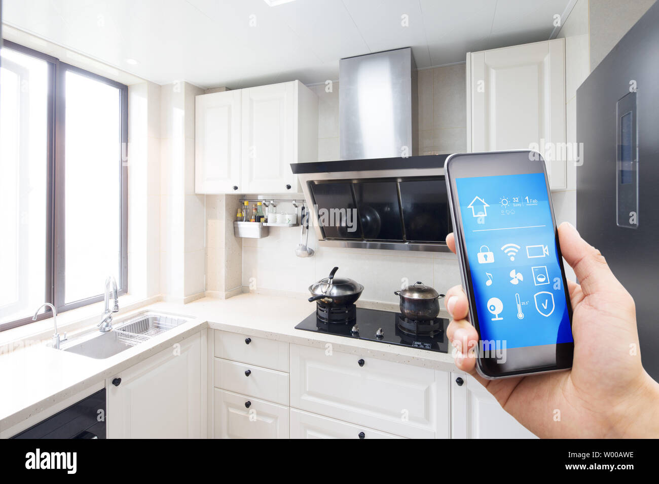 Smart Phone With Smart Home With Modern Kitchen Stock Photo