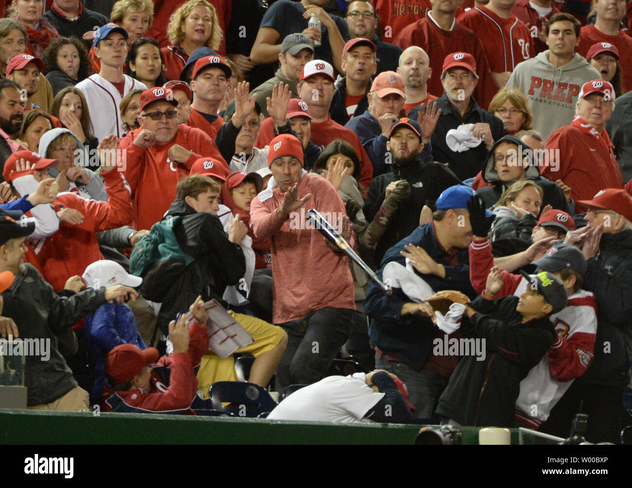 Fans react to a bat flying into the stands on a swing by Washington