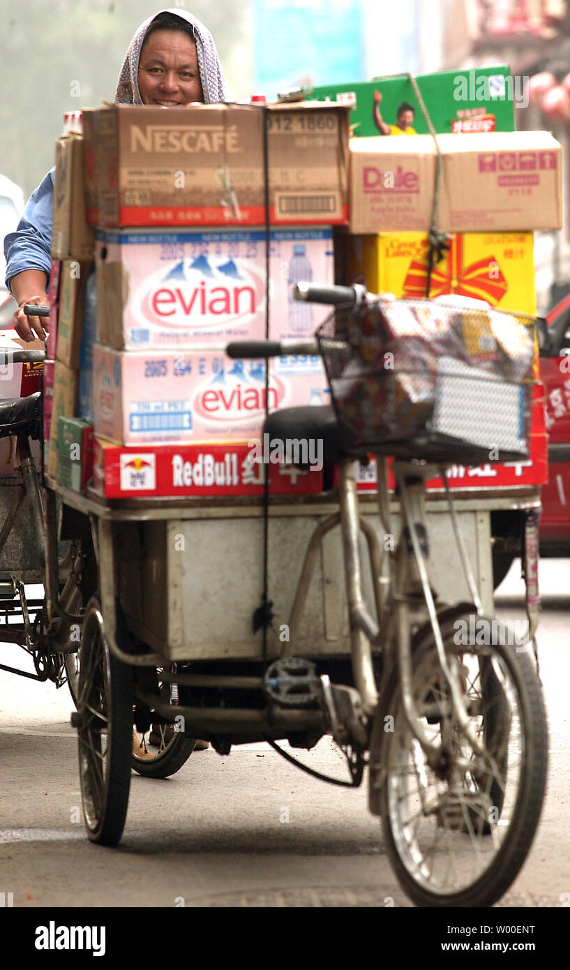 A Chinese courier delivers international goods to a restaurant in central Beijing, July 14, 2006. China remains one of the world's largest consumer markets, keeping it the focus of intense economic interest by the rest of the world.  (UPI Photo/Stephen Shaver) Stock Photo