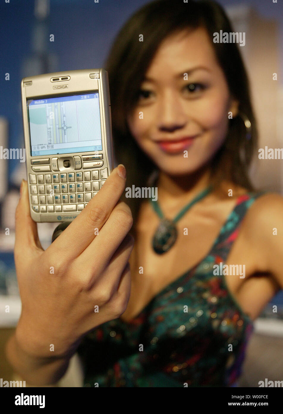 A Chinese model displays Nokia's latest mobile phone, the E62,  at Nokia's 'Our Mobile Life 2007' conference in Beijing, China. on December 03, 2006.  Nokia, the world's biggest cell- phone maker, expects the number of handset users in China to rise 11 percent to more than 500 million in 2007, boosted by growth in rural areas.  The country will add a further 160 million users from next year until 2010, Espoo, Finland-based Nokia said in a statement issued in Beijing today. China had 449 million users as of October, more than the populations of Japan and the U.S. combined.  (UPI Photo/Stephen S Stock Photo