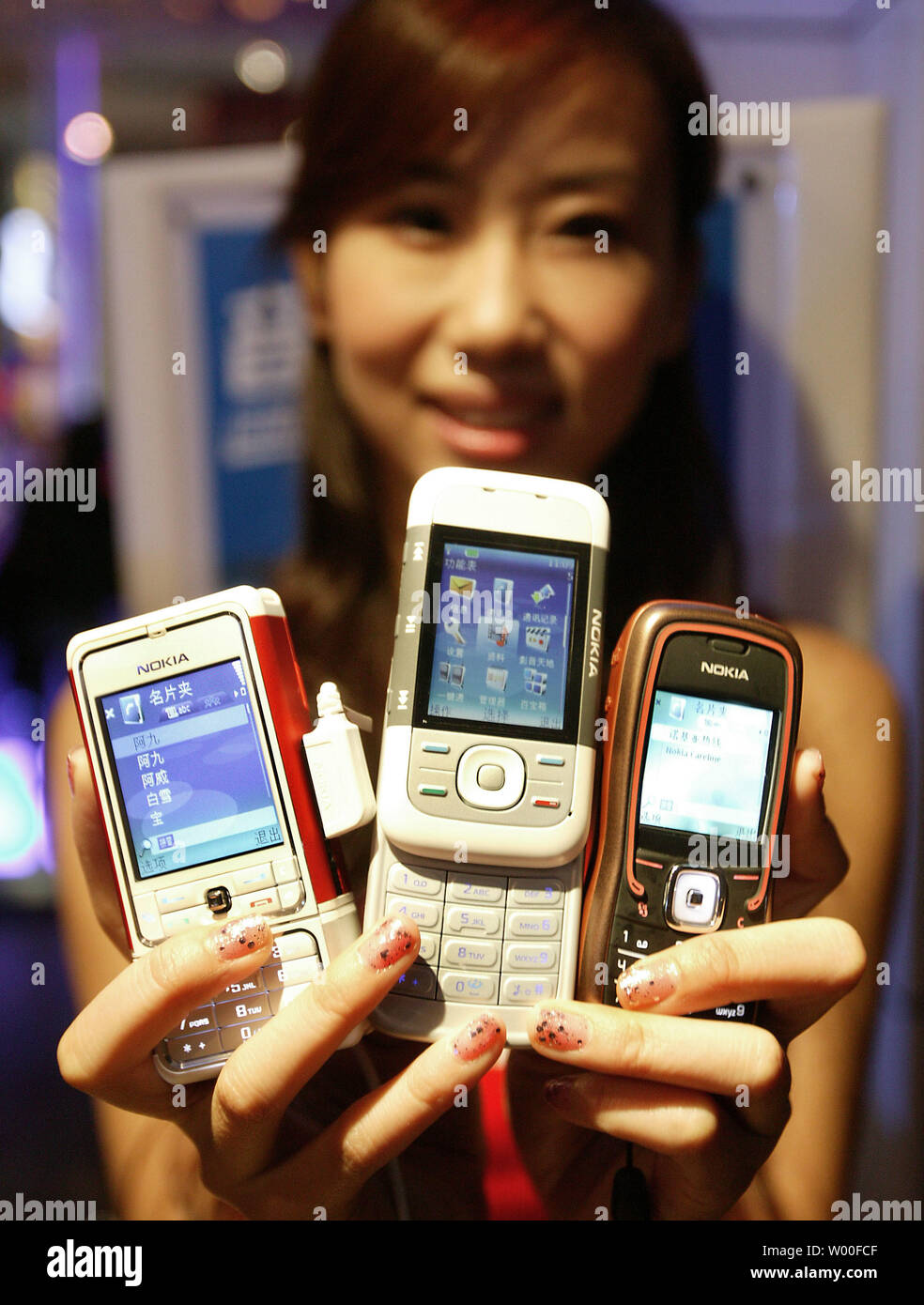 A Chinese model holds Nokia's 5000 series mobile phones on display at Nokia's 'Our Mobile Life 2007' conference in Beijing, China. on December 03, 2006. Nokia, the world's biggest cell- phone maker, expects the number of handset users in China to rise 11 percent to more than 500 million in 2007, boosted by growth in rural areas.  The country will add a further 160 million users from next year until 2010, Espoo, Finland-based Nokia said in a statement issued in Beijing today. China had 449 million users as of October, more than the populations of Japan and the U.S. combined.  (UPI Photo/Stephen Stock Photo