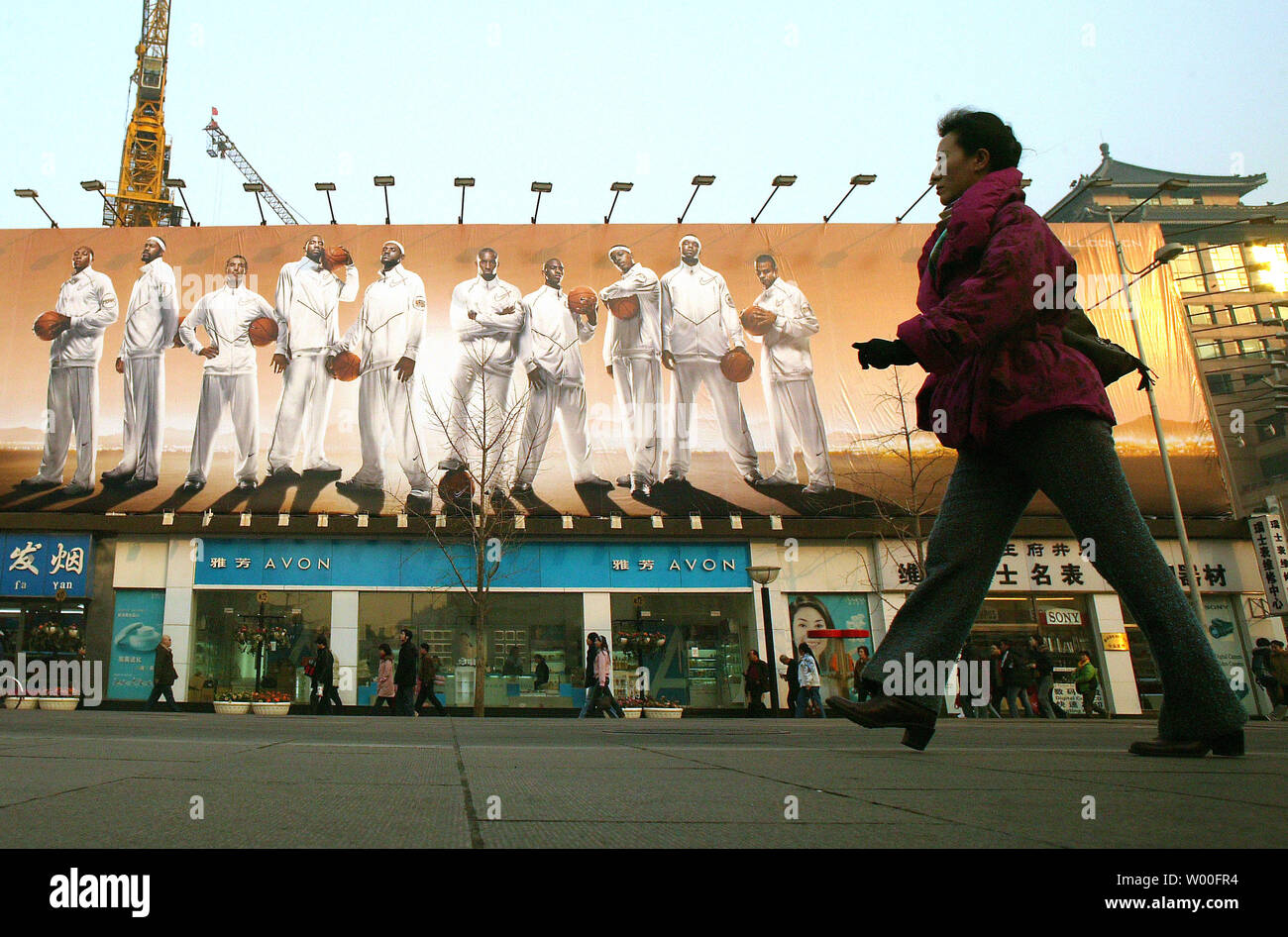 A Chinese Woman Walks Past A Massive Nike Advertisement - 