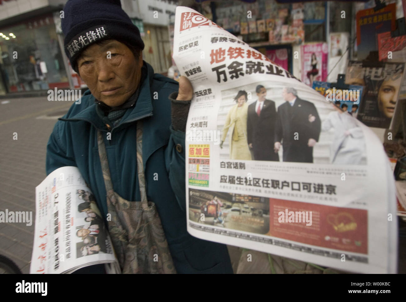 A Chinese news vendor sells newspapers featuring front-page coverage of U.S. President Barack Obama's inauguration as the 44th President of America in Beijing January 21, 2009. China offered a nervous welcome to U.S. President Barack Obama, expressing concern over the direction he may take bilateral ties while paying tribute to the efforts of George W. Bush. China censored parts of  Obama's inauguration speech on websites and state TV. (UPI Photo/Stephen Shaver) Stock Photo