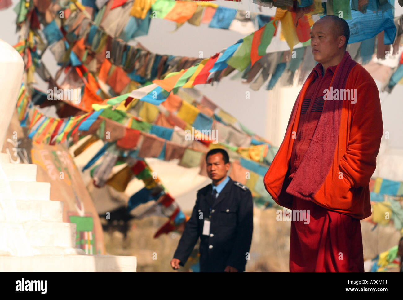 Watched by security, a monk, on hire, works at a replica of an Altar Temple in Lhasa, Tibet which represents one part of the 56 ethnic groups showcased by Han Chinese in Beijing's China Nationalities Museum, or Chinese Ethnic Cultural Park, March 15, 2009. China accused the U.S. Congress last week of damaging relations and meddling in China's internal affairs by passing a resolution recognizing the plight of Tibet's people and their exiled spiritual leader, the Dalai Lama. (UPI Photo/Stephen Shaver) Stock Photo