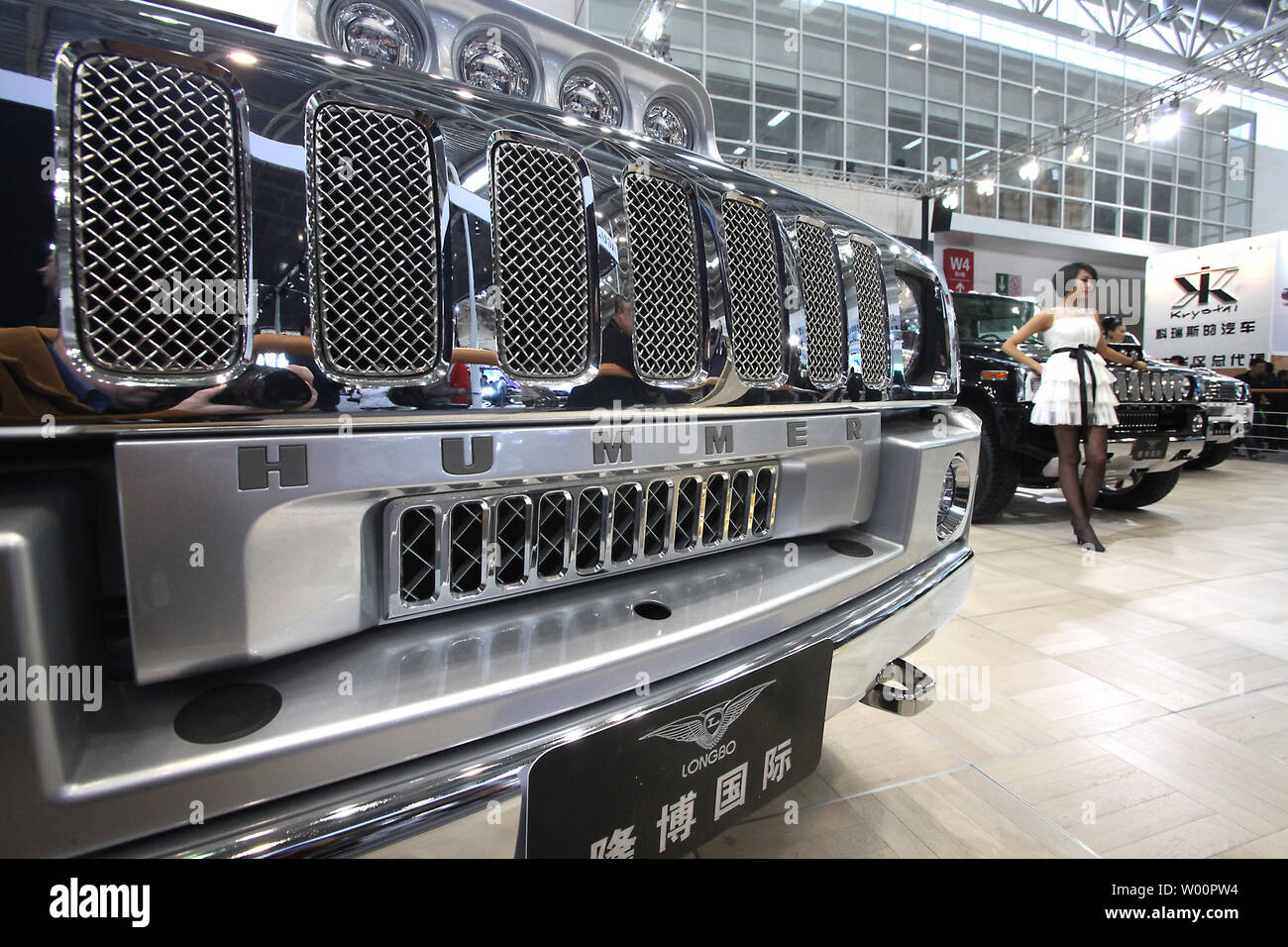 A Chinese model poses next to a Hummer at Beijing s international