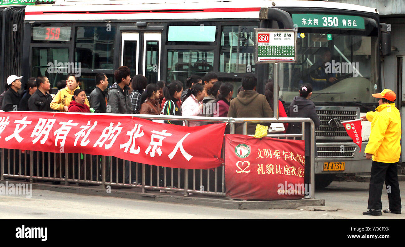 Chinese commuters stand in line to board an arriving bus in downtown Beijing on April 30, 2010.  Chinese Premier Wen Jiabao last week calld for greater efforts to fulfill the energy-aving and emission reduction goals set out in the nation's 11th Five Year Plan.  According to the plan laid out in 2006, China will cut its per unit GDP energy consumption by 20 percent compared with 2005 levels by the end of this year.    UPI/Stephen Shaver Stock Photo