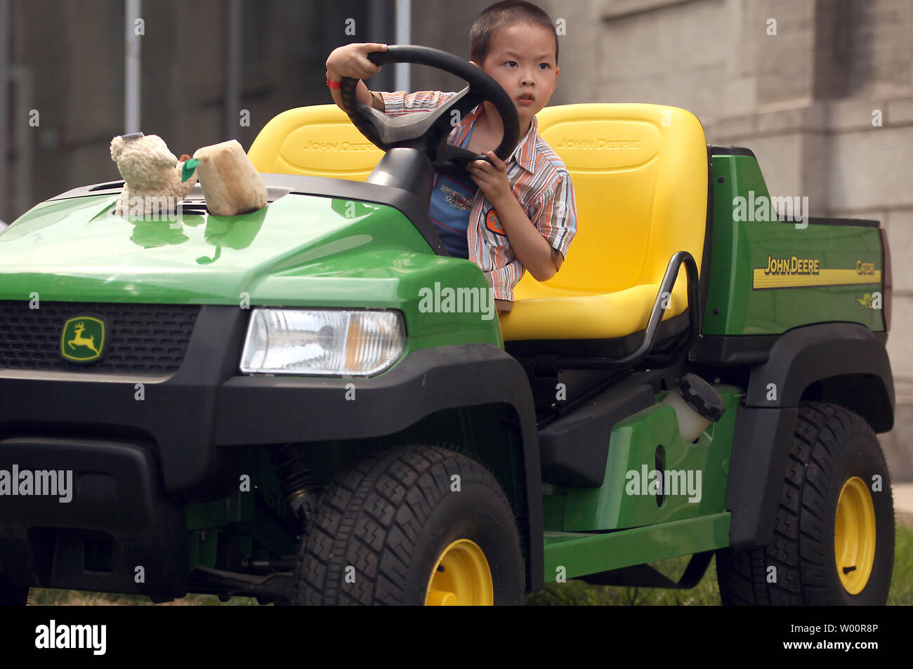 A Chinese boy pretends to drive a John Deere utility vehicle during a 4th of July Independence Day celebration and barbecue sponsored by the American Chamber of Commerce-China in Beijing on July 4, 2010.     UPI/Stephen Shaver Stock Photo