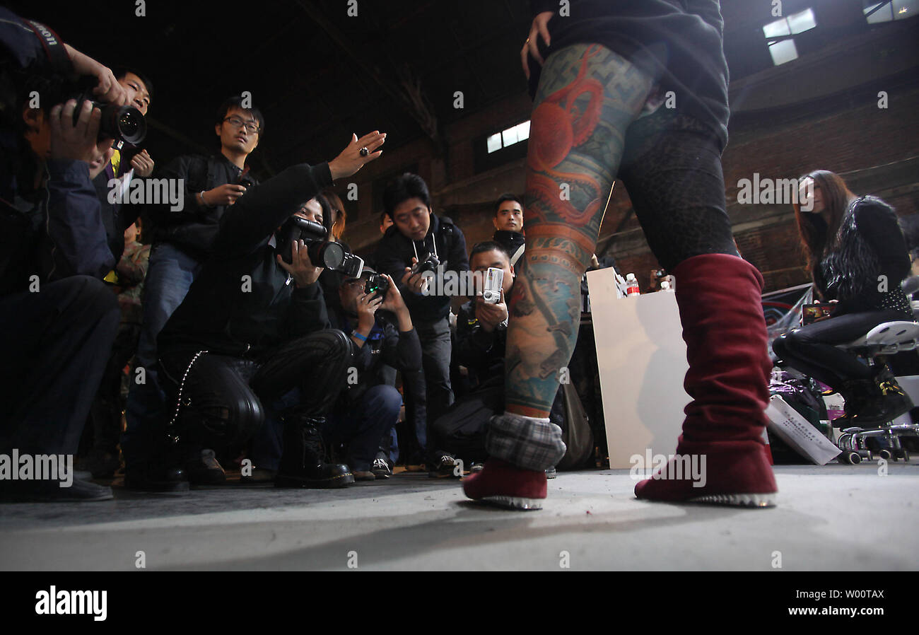 A heavily tattooed Chinese woman poses for photographers during the Beijing International Tattoo Convention being held in Beijing's 798 Art zone October 17, 2010.     UPI/Stephen Shaver Stock Photo