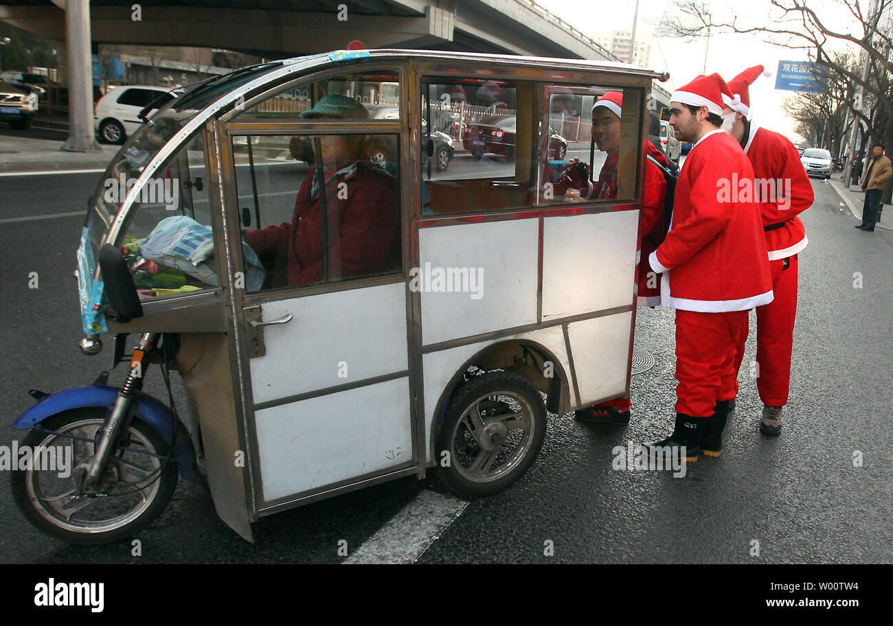 Foreigners dressed in Santa Claus costumes pile into a small 'taxi' as they make their way to Tiananmen Square for SantaCon, an annual 'Santa Claus convention celebrating cheer, goodwill and fun,' in Beijing December111, 2010.  Police on Tiananmen Square, surprised by the large gathering of people wearing red, ordered the group to disperse and leave the square while also harassing foreign journalists, detaining one. Tiananmen Square was under tight security as the Nobel Peace Prize ceremony was held in Norway.      UPI/Stephen Shaver Stock Photo