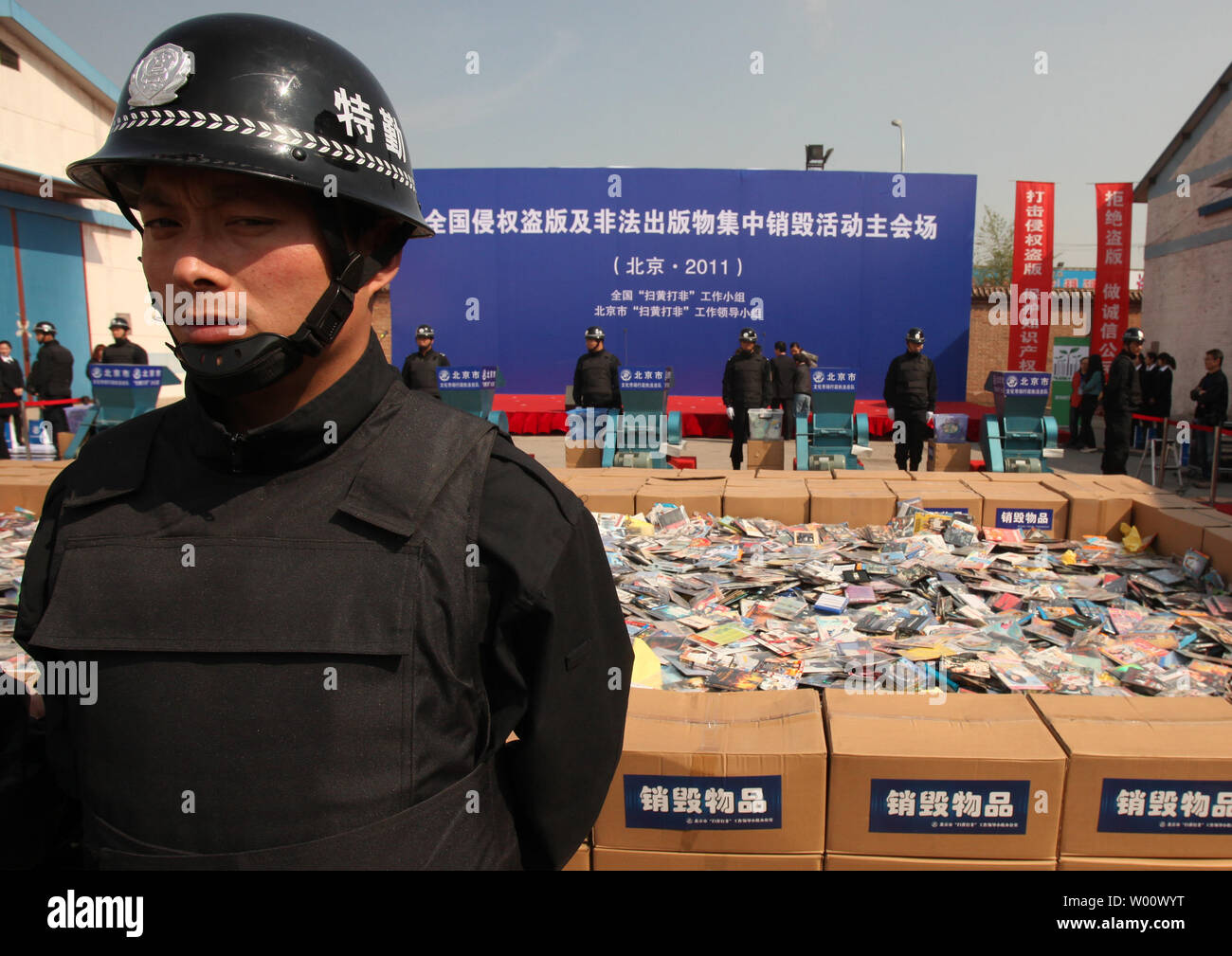 Policemen stand next to machines that will destroy the pornographic and pirated publications on display at the Beijing Warehouse of Confiscated Goods on April 22, 2011.  Thousands of pirated DVDs and CDs were destroyed in China's capital, kicking off a nationwide campaign to crack down on piracy across the country.          UPI/Stephen Shaver Stock Photo