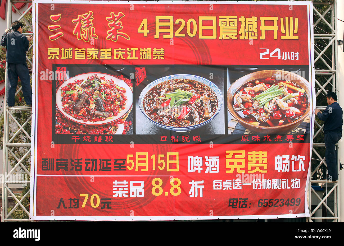 Chinese Workers Hang A Giant Advertisement For A Sichuan Restaurant In Beijing On April 28 2011 Soaring Food And Fuel Prices Are Threatening To Derail Growth In Asian Economies According To A