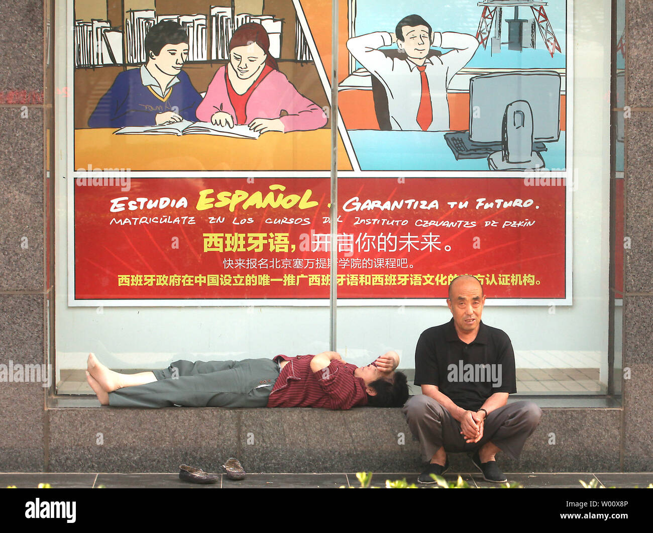 A Chinese couple sits in front of a Spanish cultural center, specializing in teaching Spanish to locals, in Beijing on May 26, 2011.  China is confident Spain will recover from its economic crisis as Beijing continues to buy Spanish public debt despite market fears of an Irish-style bailout.        UPI/Stephen Shaver Stock Photo