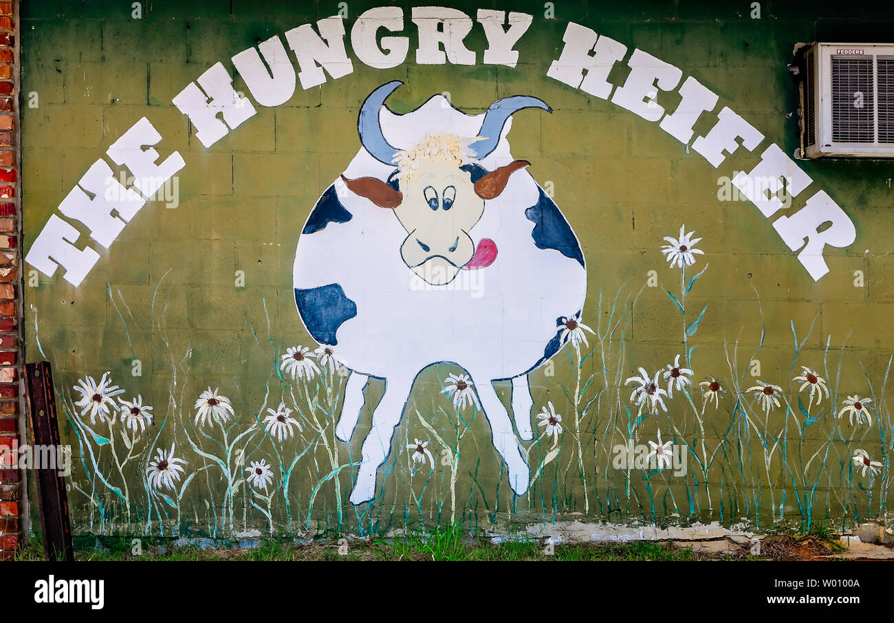 A black and white cow is featured on the wall of an abandoned restaurant, June 23, 2019, in Meridian, Mississippi. Stock Photo