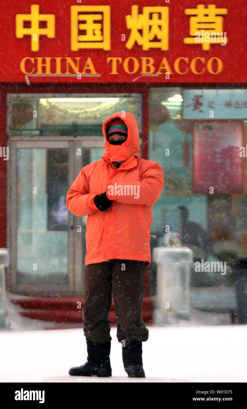 A Chinese man stands in front of a tobacco and liquor store in Harbin, the  capital of the China's northern Heilongjiang Province near Russia, February  28, 2012. As the biggest tobacco producer