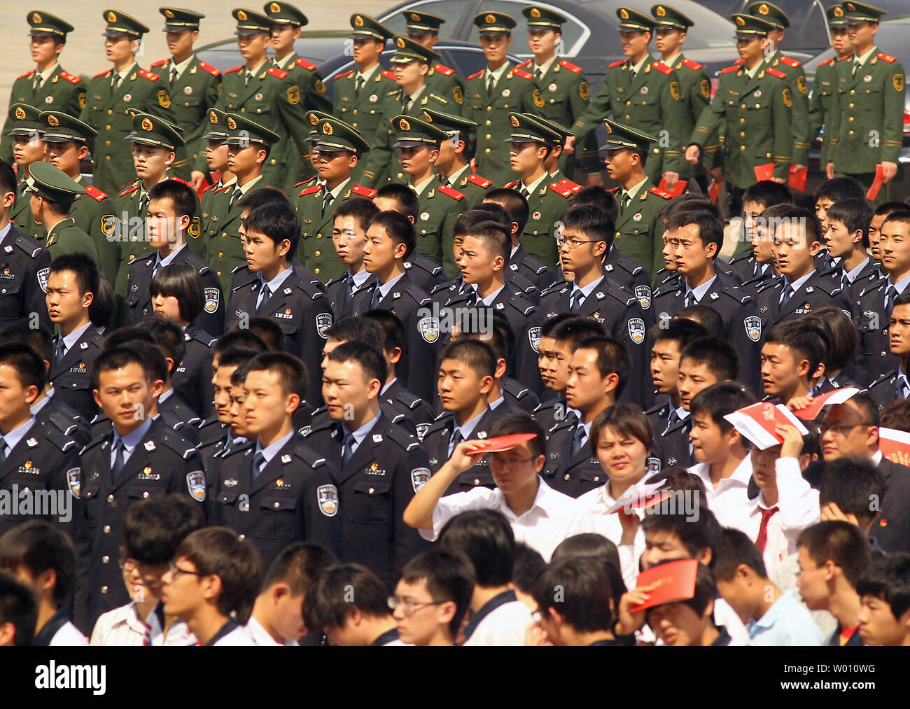 Young soldiers  and students wait outside the Great Hall of the People with their red entry tickets to attend the 'Celebration of the 90th Anniversary of the Communist Youth League of China' in Beijing on May 4, 2012.  Recent events involving human rights and corruption have cast some doubt on the Chinese Communist Party's continued ability to maintain a firm grip on the state apparatus and Chinese society, according to both academics and analysts working in China.   UPI/Stephen Shaver Stock Photo