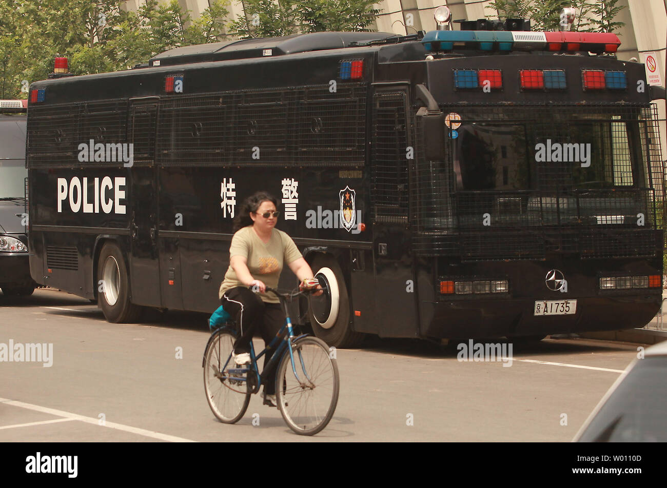 A Chinese woman cycles past a row of riot-equipped police vehicles parked near Beijing's Tiananmen Square as heavy security surrounded the square on the 33rd anniversary of the 1989 military crackdown on students, on June 4, 2012.   China has expressed 'strong dissatisfaction'' with a recent U.S. government statement urging the government to free student protestors imprisoned after the 1989 crackdown.      UPI/Stephen Shaver Stock Photo