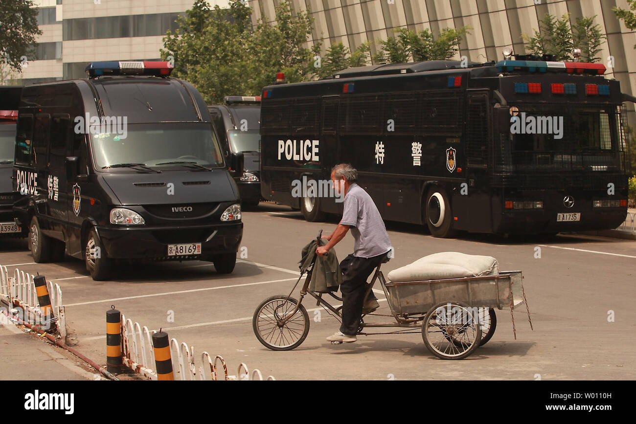 A Chinese man cycles past a row of riot-equipped police vehicles parked near Beijing's Tiananmen Square as heavy security surrounded the square on the 33rd anniversary of the 1989 military crackdown on students, on June 4, 2012.  China has expressed 'strong dissatisfaction'' with a recent U.S. government statement urging the government to free student protestors imprisoned after the 1989 crackdown.      UPI/Stephen Shaver Stock Photo